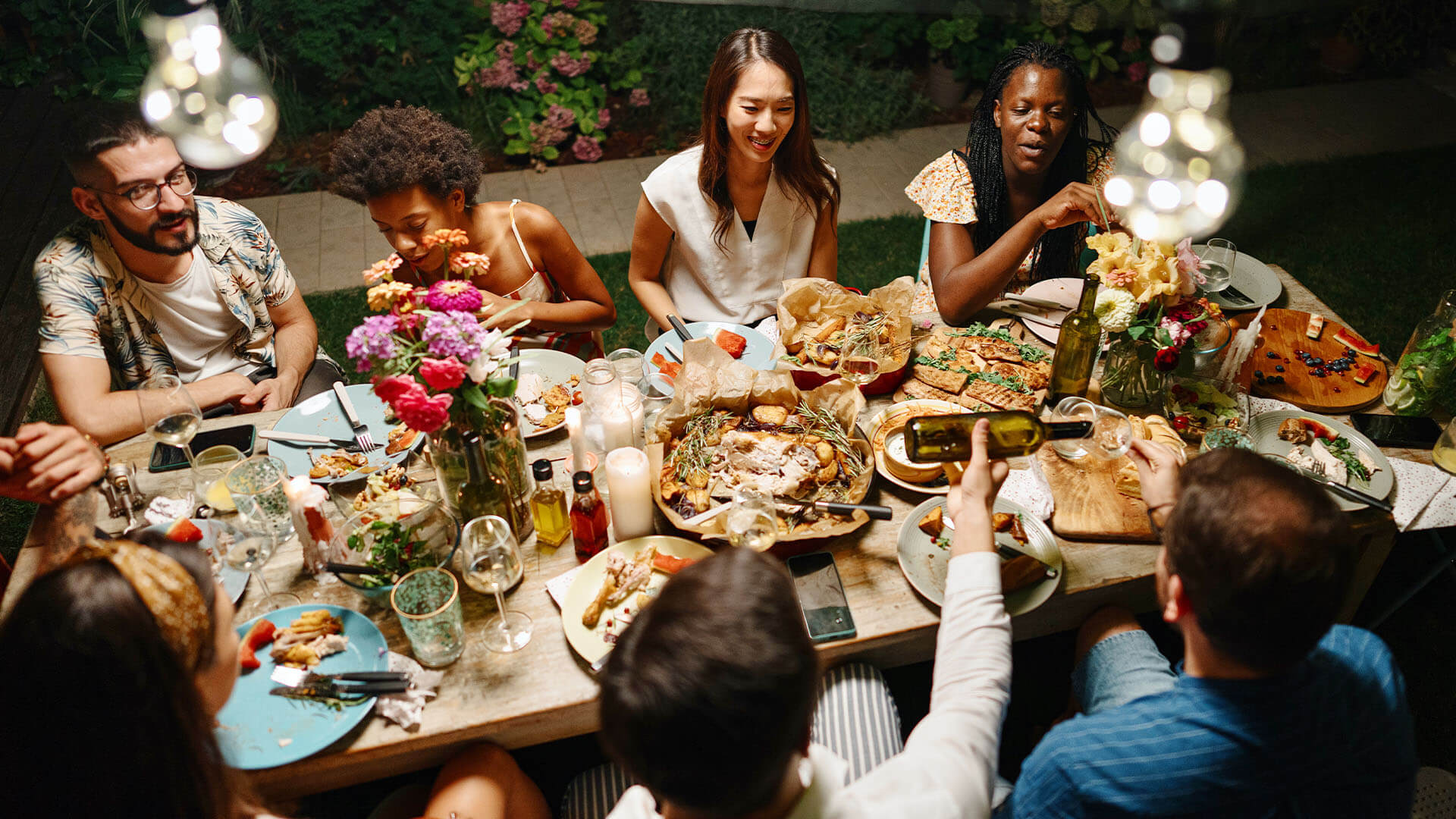 A group of friends gathered around a table enjoying a feast: tips on surviving Christmas and festive season when you're gluten free