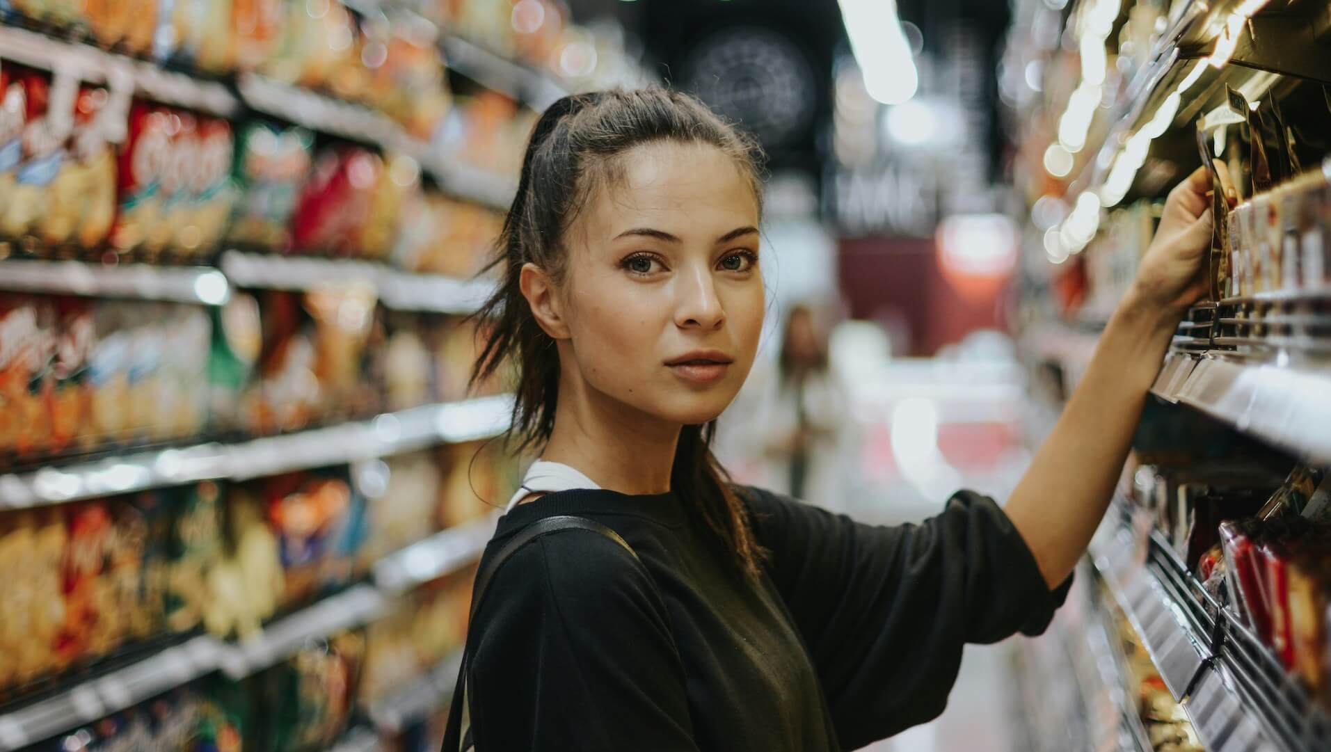 Gluten-free Living Add to Cart: woman at supermarket picking items off the shelf