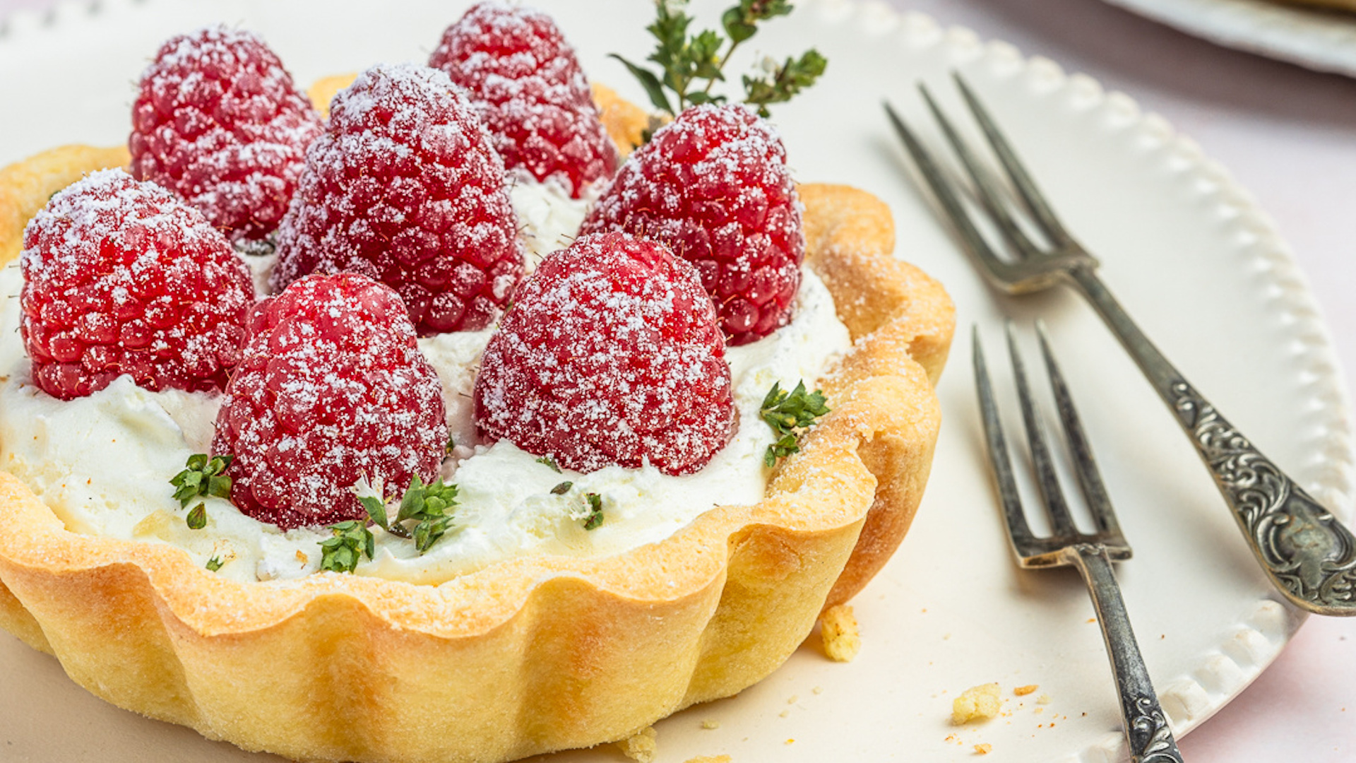 Gluten-Free Living: a tart shell filled with cream and fresh raspberries, dusted with icing sugar.